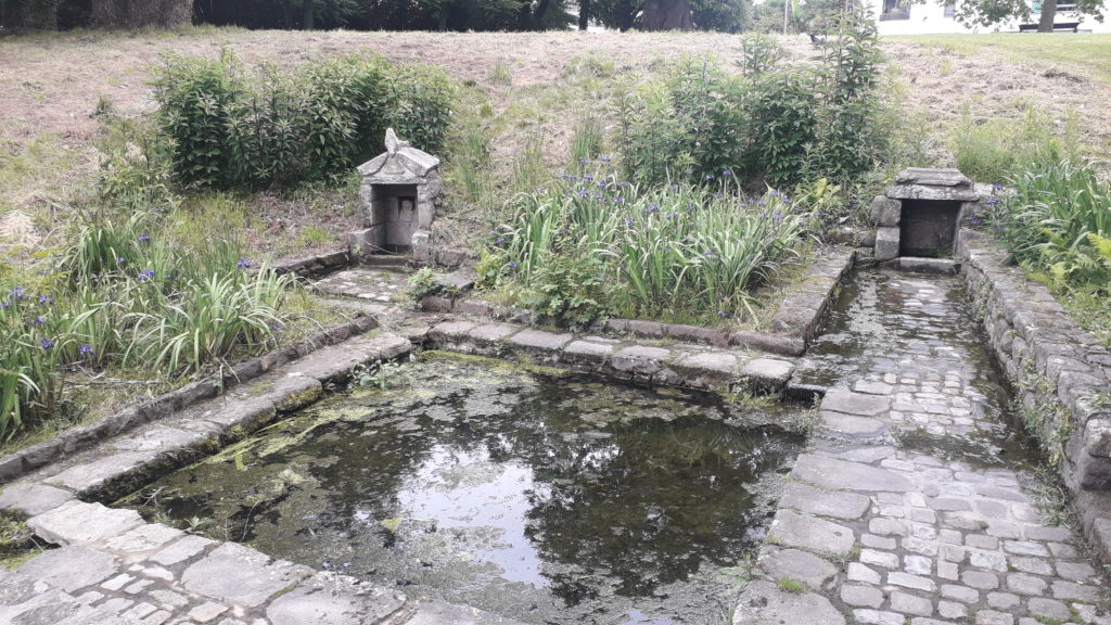Cette photo montre un bassin et deux petites fontaines d'eau de source, construits en vieilles pierres, situés dans un jardin public en Bretagne. A cet endroit, quand j'étais petite, se trouvait une décharge publique.